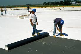 Employees working on a TPO roofing system