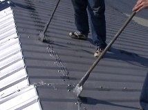 Employees installing a metal roof