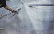 Employee applying polyurethane to a roof